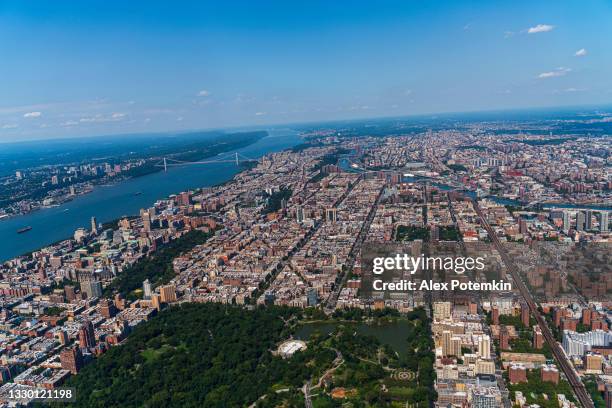 aerial view of central park, manhattan, and harlem, and the bronx in a distance behind, from a helicopter on a sunny summer day. - central-park-manhattan stockfoto's en -beelden