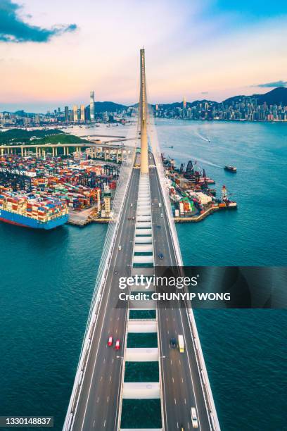 drohnenansicht der stonecutters bridge und des tsing sha highway bei sonnenuntergang - containerschiff stock-fotos und bilder