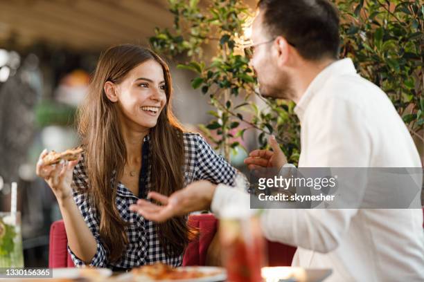 happy couple talking during a meal in a restaurant. - pizzeria stockfoto's en -beelden