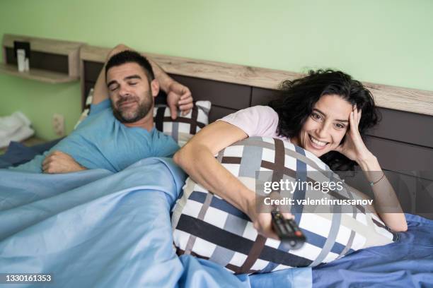 allegra coppia di adulti che guardano la tv a casa a letto - man funny pajamas foto e immagini stock