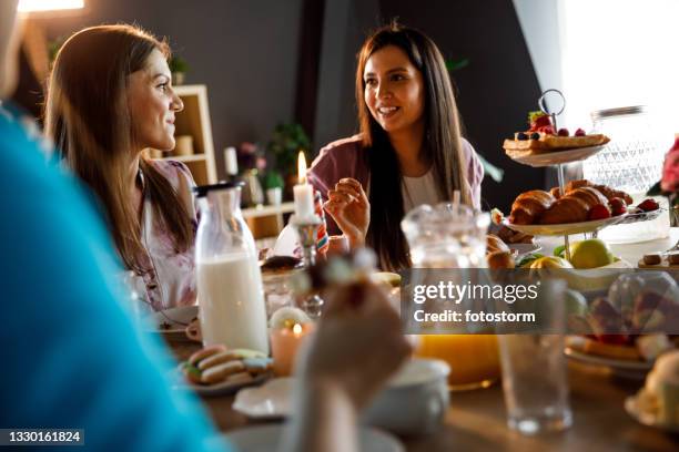 freundinnen plaudern beim genießen von leckerem essen während des brunchs - nachmittagstee stock-fotos und bilder