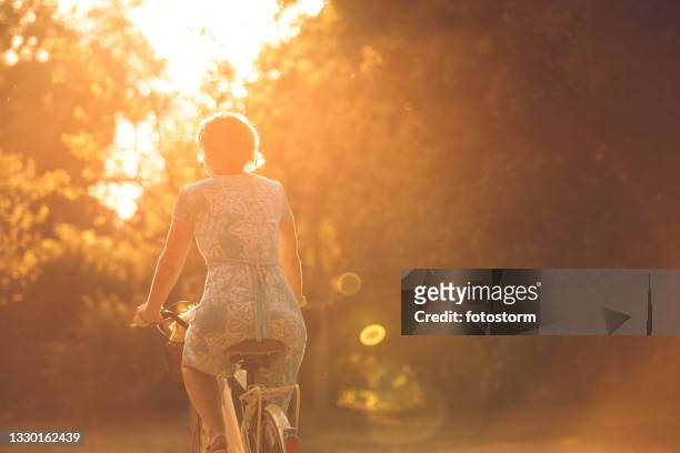 mit dem fahrrad in den sommersonnenuntergang - goldene stunde stock-fotos und bilder