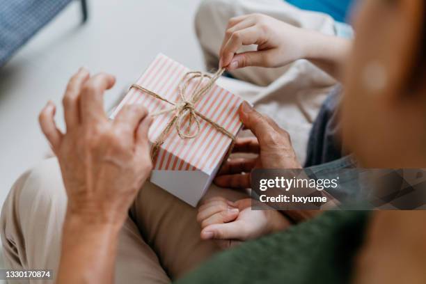 grandmother and grandchild opening a gift box - happy birthday images for women stock pictures, royalty-free photos & images