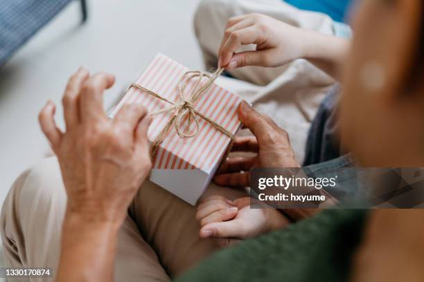 grandmother and grandchild opening a gift box - gifts stock pictures, royalty-free photos & images