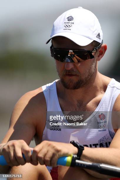 John Collins of Team Great Britain looks on at the start line as the reflection of his hands is seen in his sunglasses before he competes in the...