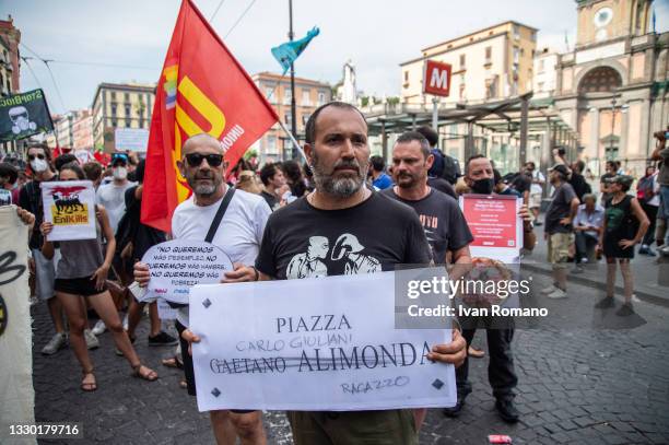 Man shows the photograph of the plaque in Piazza Alimonda where Carlo Giuliani died in Genoa during the 2001 G8, during the No G20 protest on July...