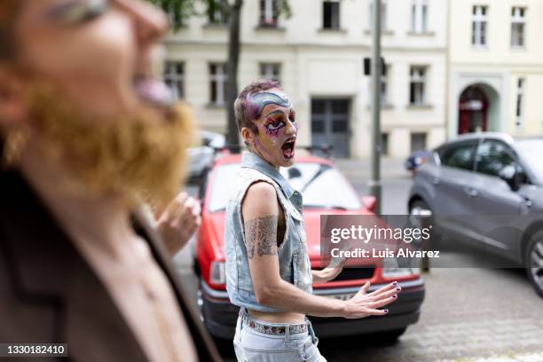 group of genderqueer person friends walking outdoors in drag attire - crossdressing party fotografías e imágenes de stock