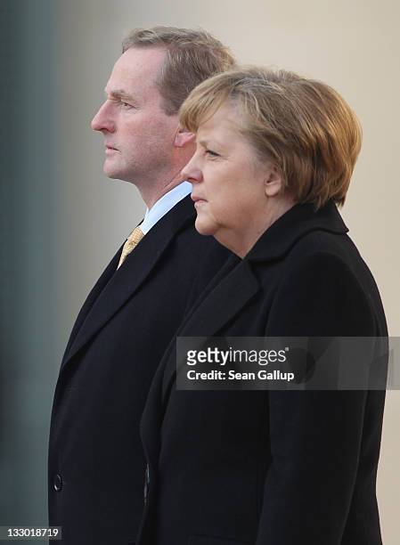 Irish Prime Minister Enda Kenny and German Chancellor Angela Merkel listen to their countries' national anthems upon Kenny's arrival at the...