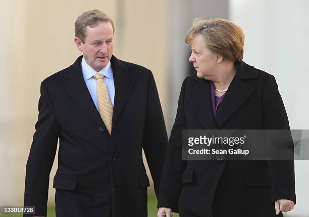 Irish Prime Minister Enda Kenny and German Chancellor Angela Merkel walk toward a guard of honour upon Kenny's arrival at the Chancellery on November...