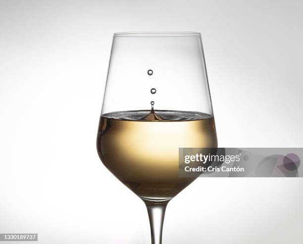 white wine splashing in glass - wine splashing stock pictures, royalty-free photos & images