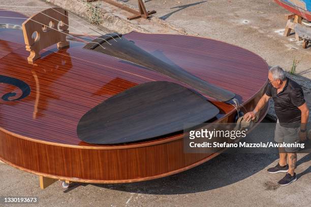 Builders finish preparing violin boat before press presentation on July 23, 2021 in Venice, Italy. The violin boat will be launched in September and...