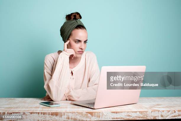 woman working with laptop and mobile, studio shot - female worried mobile imagens e fotografias de stock