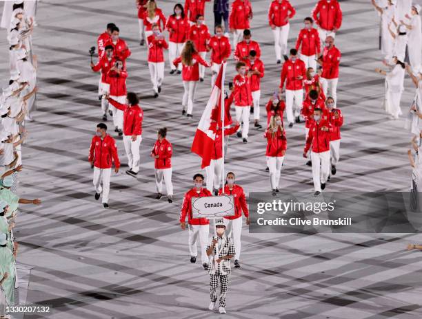 Flag bearers Miranda Ayim and Nathan Hirayama of Team Canada lead their team out during the Opening Ceremony of the Tokyo 2020 Olympic Games at...