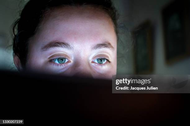 young woman eyes watching a computer screen - woman laptop screen stock-fotos und bilder