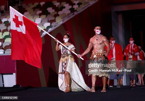 Flag bearers Malia Paseka and Pita Taufatofua of Team Tonga lead their team out during the Opening Ceremony of the Tokyo 2020 Olympic Games at...