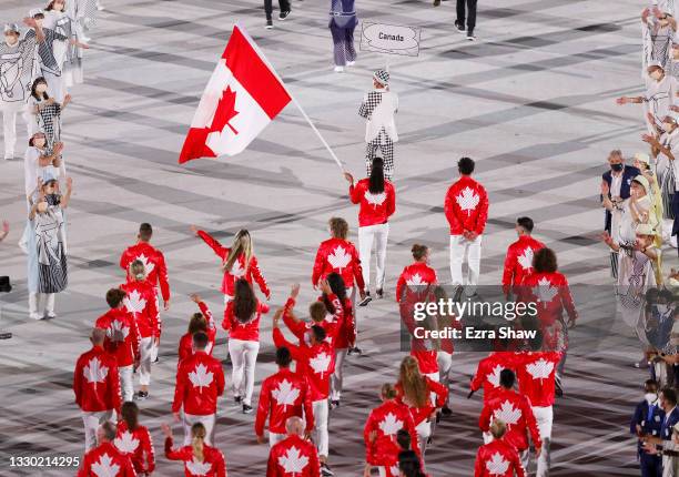 Flag bearers Miranda Ayim and Nathan Hirayama of Team Canada lead their team out during the Opening Ceremony of the Tokyo 2020 Olympic Games at...