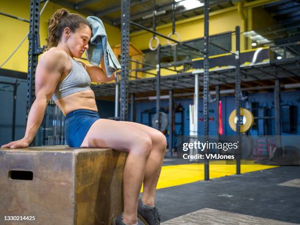 female bodybuilder using muscle creams and aerosols - female bodybuilder stock pictures, royalty-free photos & images