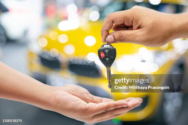 hand of business man gives the car key - salón de coches fotografías e imágenes de stock