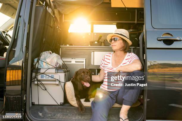 woman sitting in camper van with her pet dog - motorhome france stock pictures, royalty-free photos & images