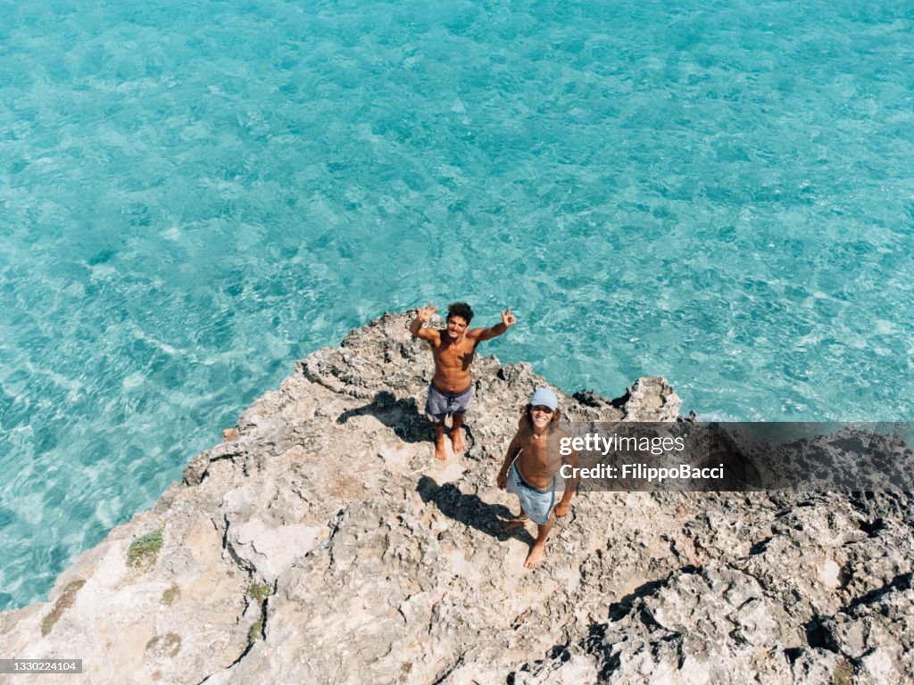 Two friends are looking up, saying hello to the drone