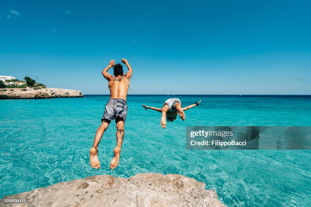 Dos amigos se zambullyn en el mar desde un acantilado