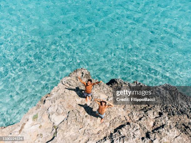 two friends are looking up, saying hello to the drone - palma maiorca 個照片及圖片檔