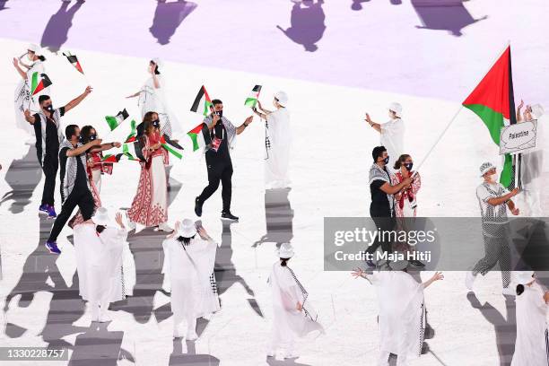 Flag bearers Dania Nour and Mohammed K H Hamada of Team Palestine lead their team during the Opening Ceremony of the Tokyo 2020 Olympic Games at...