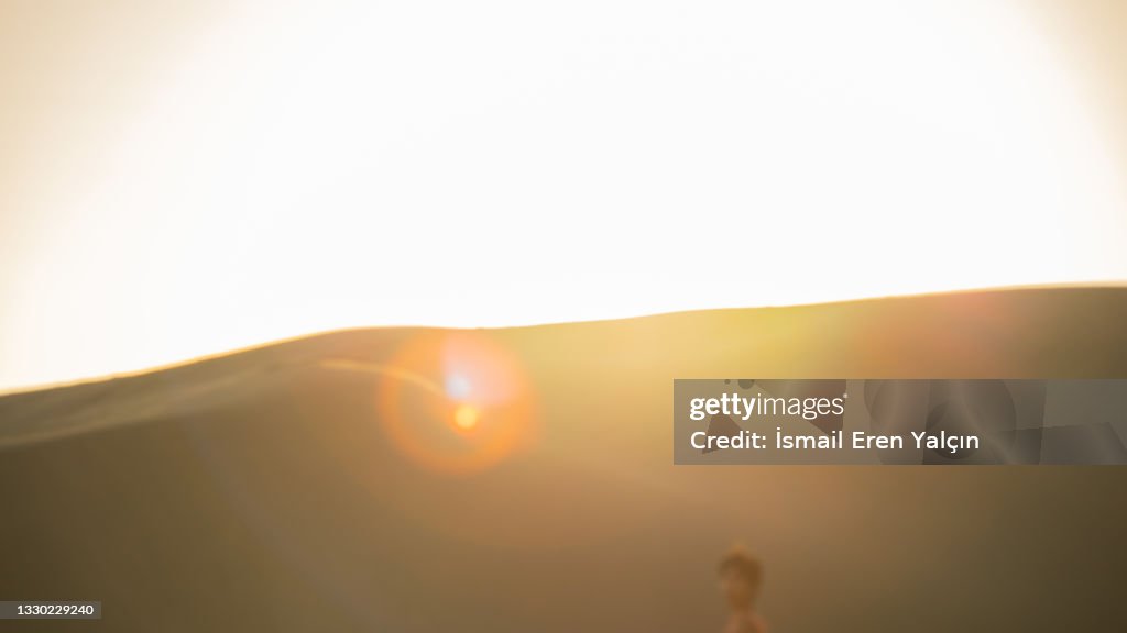 Model posing on the beach in silhouette and backlight