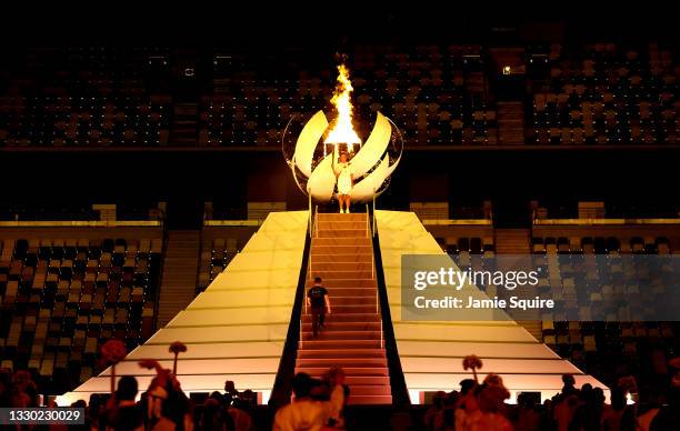 Naomi Osaka of Team Japan lights the Olympic cauldron with the Olympic torch during the Opening Ceremony of the Tokyo 2020 Olympic Games at Olympic...