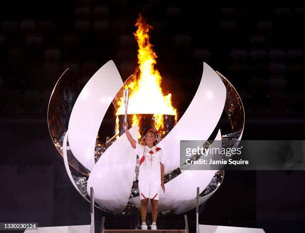 Naomi Osaka of Team Japan lights the Olympic cauldron with the Olympic torch during the Opening Ceremony of the Tokyo 2020 Olympic Games at Olympic...
