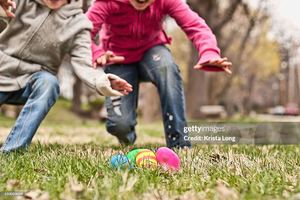 Two children running towards easter eggs