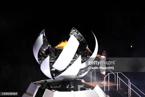 Naomi Osaka of Team Japan lights the Olympic cauldron with the Olympic torch during the Opening Ceremony of the Tokyo 2020 Olympic Games at Olympic...