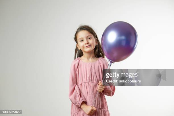 chica sosteniendo globo púrpura - balloon girl fotografías e imágenes de stock