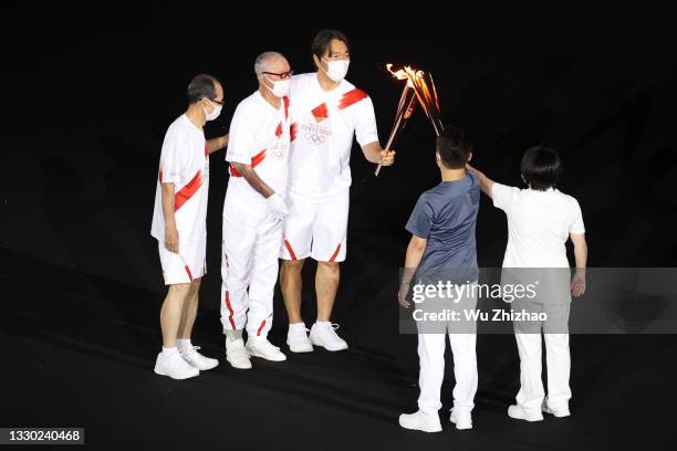 Former baseball stars Sadaharu Oh, Shigeo Nagashima and Hideki Matsui carry the Olympic torch during the Opening Ceremony of the Tokyo 2020 Olympic...