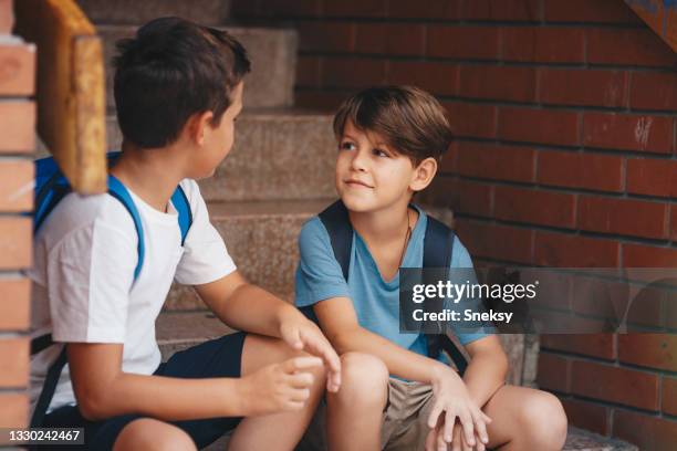 two young boys sitting on stairs and talking. - 9 steps stock pictures, royalty-free photos & images