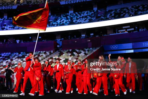 Flag bearers Jovanka Radicevic and Drasko Brguljan of Team Montenegro lead their team out during the Opening Ceremony of the Tokyo 2020 Olympic Games...