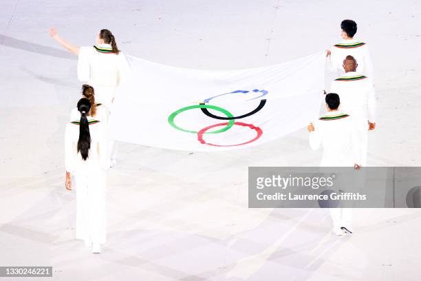 Athletes Paula Pareto, Kento Momota, Elena Galiabovitch, Cyrille Tchatchet II, Mehdi Essadiq and Paola Egonu carry the Olympic flag during the...
