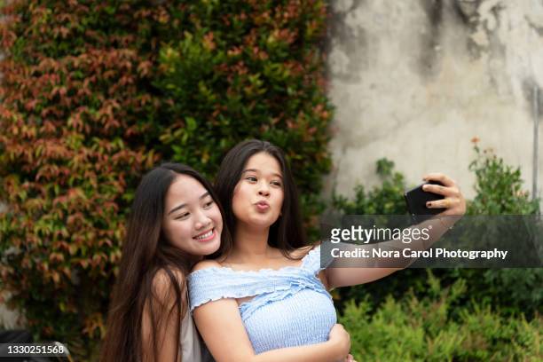 playful friends taking selfie together - malaysia beautiful girl 個照片及圖片檔