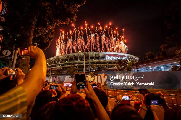 People take photographs of fireworks during the Opening Ceremony of the Tokyo 2020 Olympic Games at Olympic Stadium on July 23, 2021 in Tokyo, Japan.