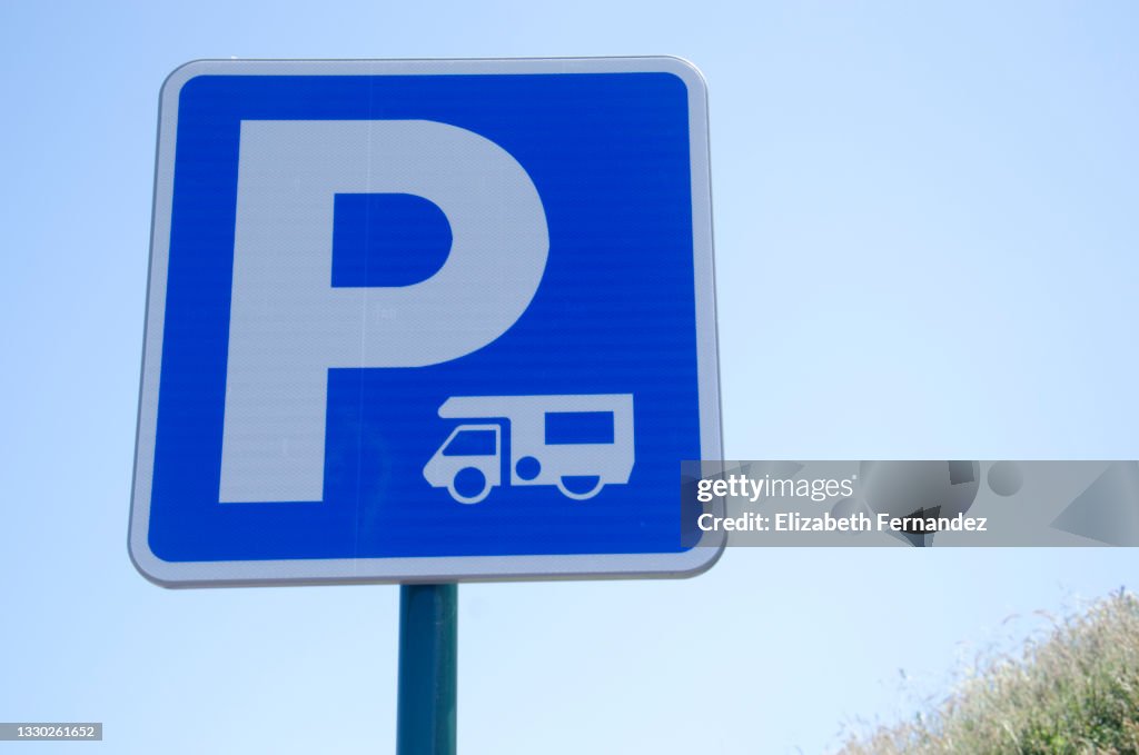 Caravan parking sign against blue sky