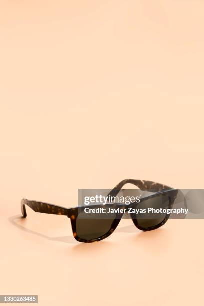 sunglasses on brown background - sonnenbrillen stock-fotos und bilder