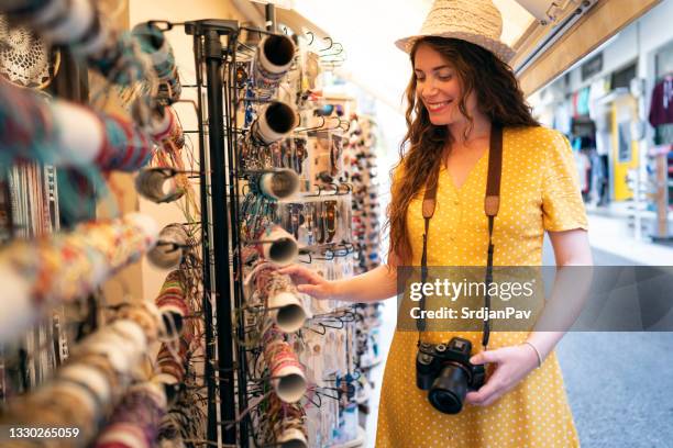 caucasian woman, solo tourist, shopping souvenirs on the street markets in vasiliki, on the island of levkas, greece. - souvenir bildbanksfoton och bilder