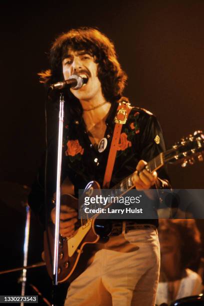 Guitarist George Harrison, formerly of the rock and roll band "The Beatles", performs onstage with an electric guitar at the Cow Palace on November...