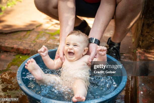 baby spielt im sommer im wasser. - babyschwimmen stock-fotos und bilder