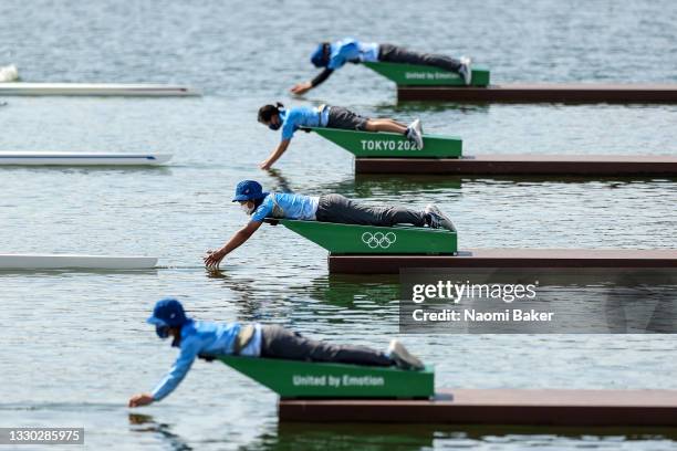 Volunteers let go of the boats during the Men's Single Sculls Repechage on day one of the Tokyo 2020 Olympic Games at Sea Forest Waterway on July 24,...