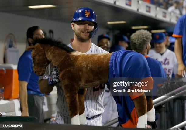 Pete Alonso of the New York Mets celebrates his home run in the eighth inning against the Toronto Blue Jays with the 'Home Run Horse' in the dugout...