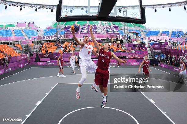 Przemyslaw Zamojski of Team Poland drives to the basket under pressure from Agnis Cavars of Team Latvia during the Men's Pool Round match between...