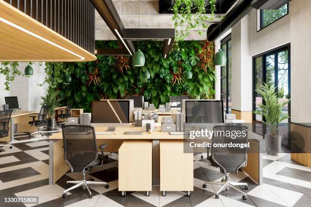 eco-friendly open plan modern office with tables, office chairs, plants and vertical garden background - office background stock pictures, royalty-free photos & images