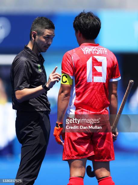 The referee talks with Manabu Yamashita of Team Japan during the Men's Pool A match against Australia on day one of the Tokyo 2020 Olympic Games at...