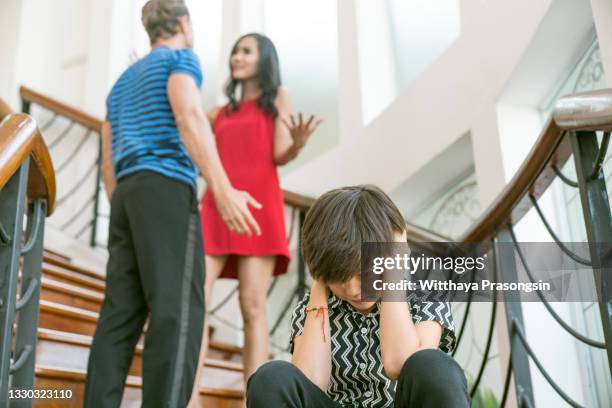 domestic violence and family conflict concepts the sadness of a little boy fighting with his parents at home quarrel. - separar imagens e fotografias de stock